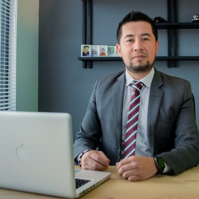 Beautiful young Latin woman driving her brand new car and showing her thumb up